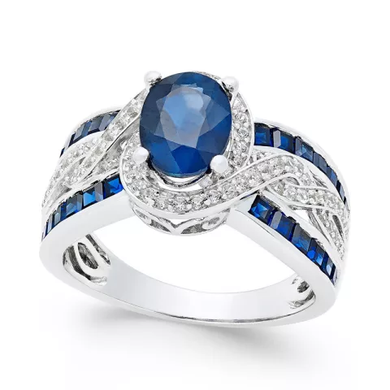 Royal blue zircon ring with oval center stone and diamond accents in a silver band.