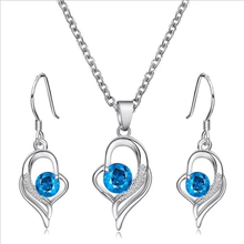 Load image into Gallery viewer, Blue crystal heart pendant necklace and earring set with silver finish.

