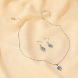 Silver necklace and earrings set with blue faux crystal pendant.