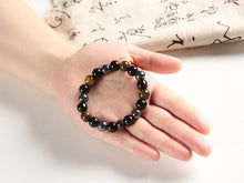 Load image into Gallery viewer, Beaded bracelet featuring hematite, tiger&#39;s eye, and obsidian stones on a hand.
