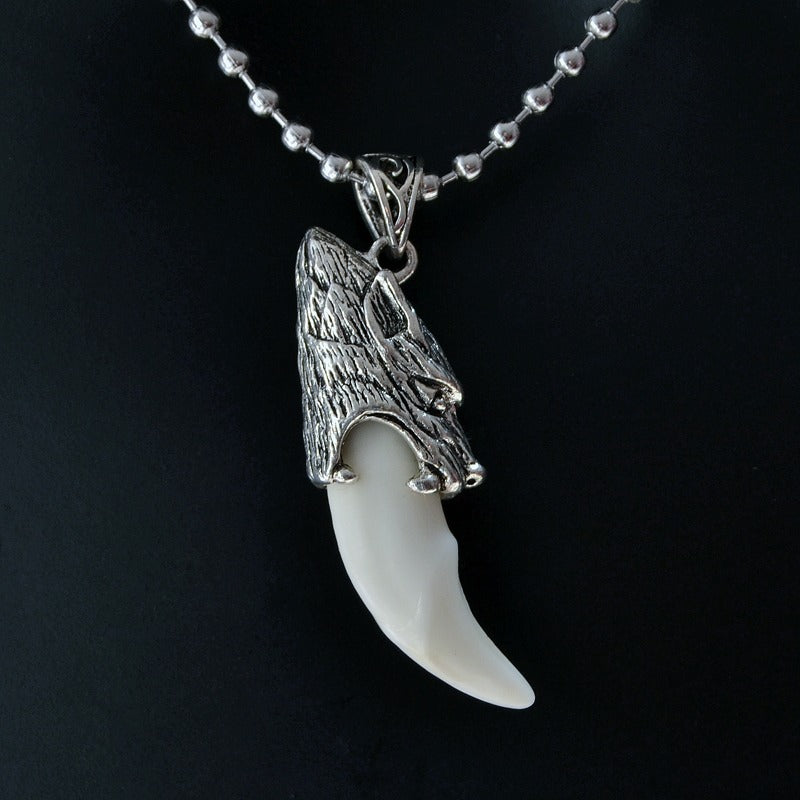 Stainless steel wolf tooth pendant necklace, featuring a detailed wolf head and smooth, white tooth.